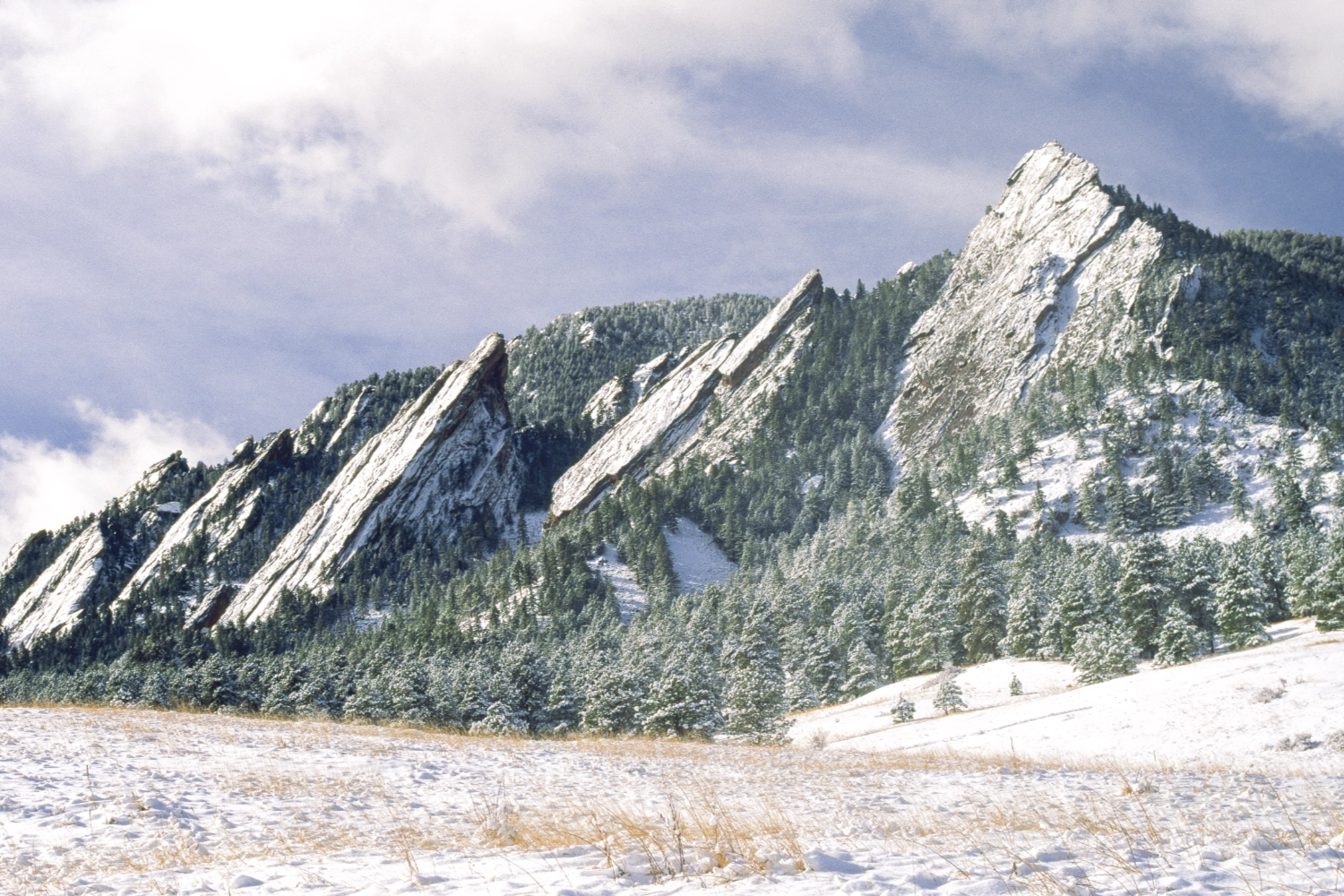 Boulder Open Space and Mountain Parks with snow-dusted Flatirons and open grassland in the foreground.